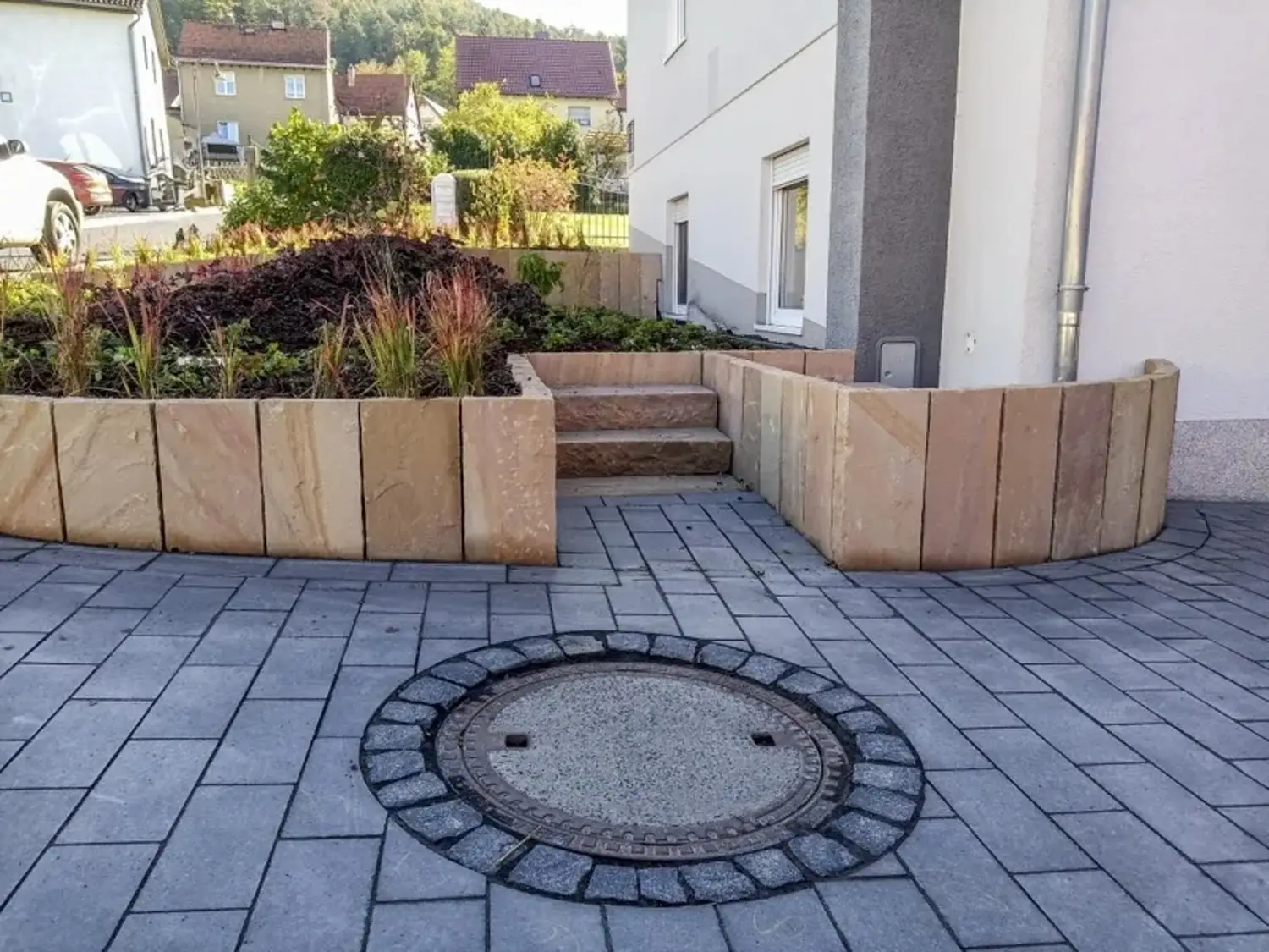 Gepflasterter Hof mit Sandsteinmauern und Treppe