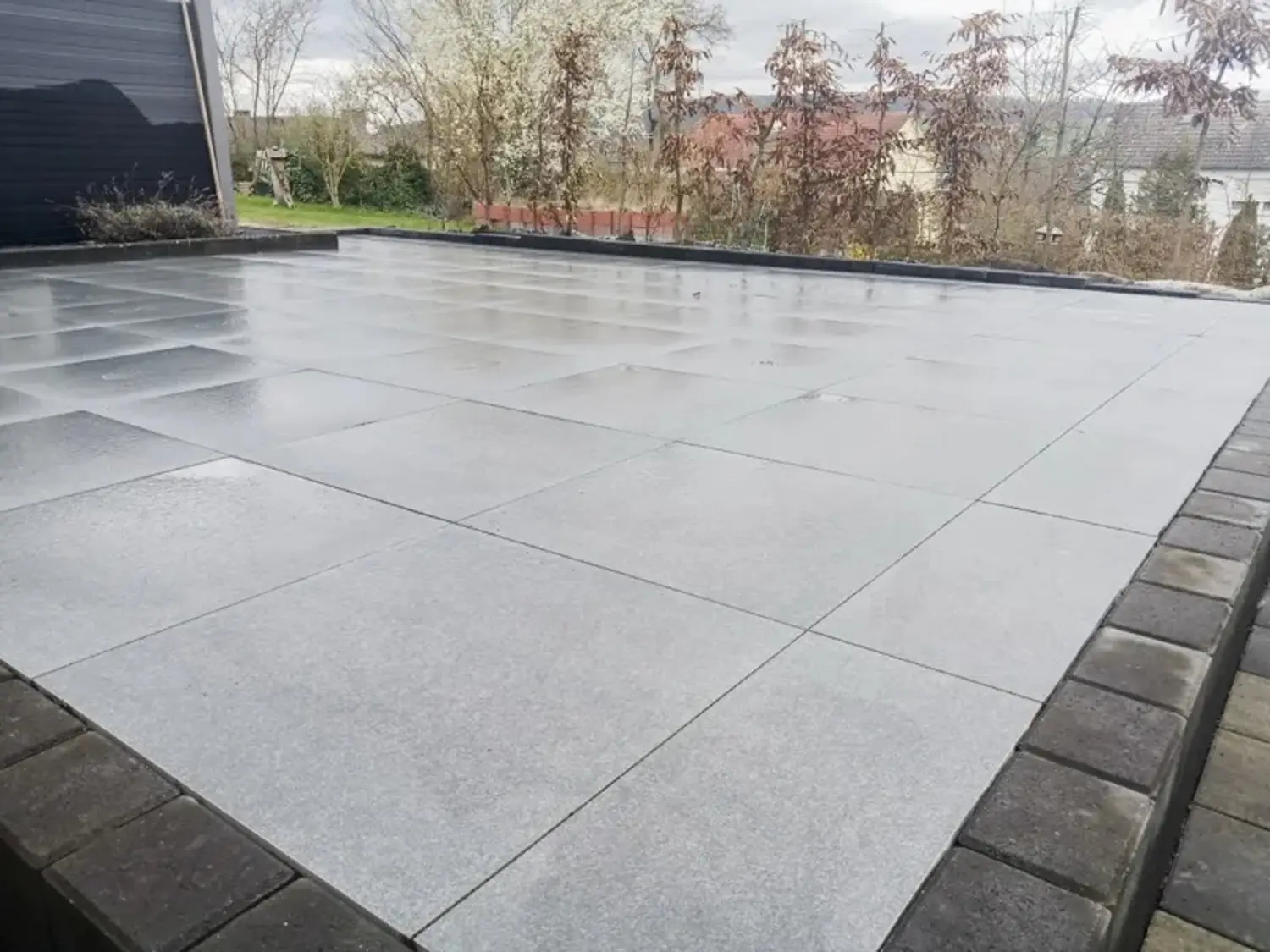 Hellgraue Terrassenplatten mit dunkler Randbegrenzung