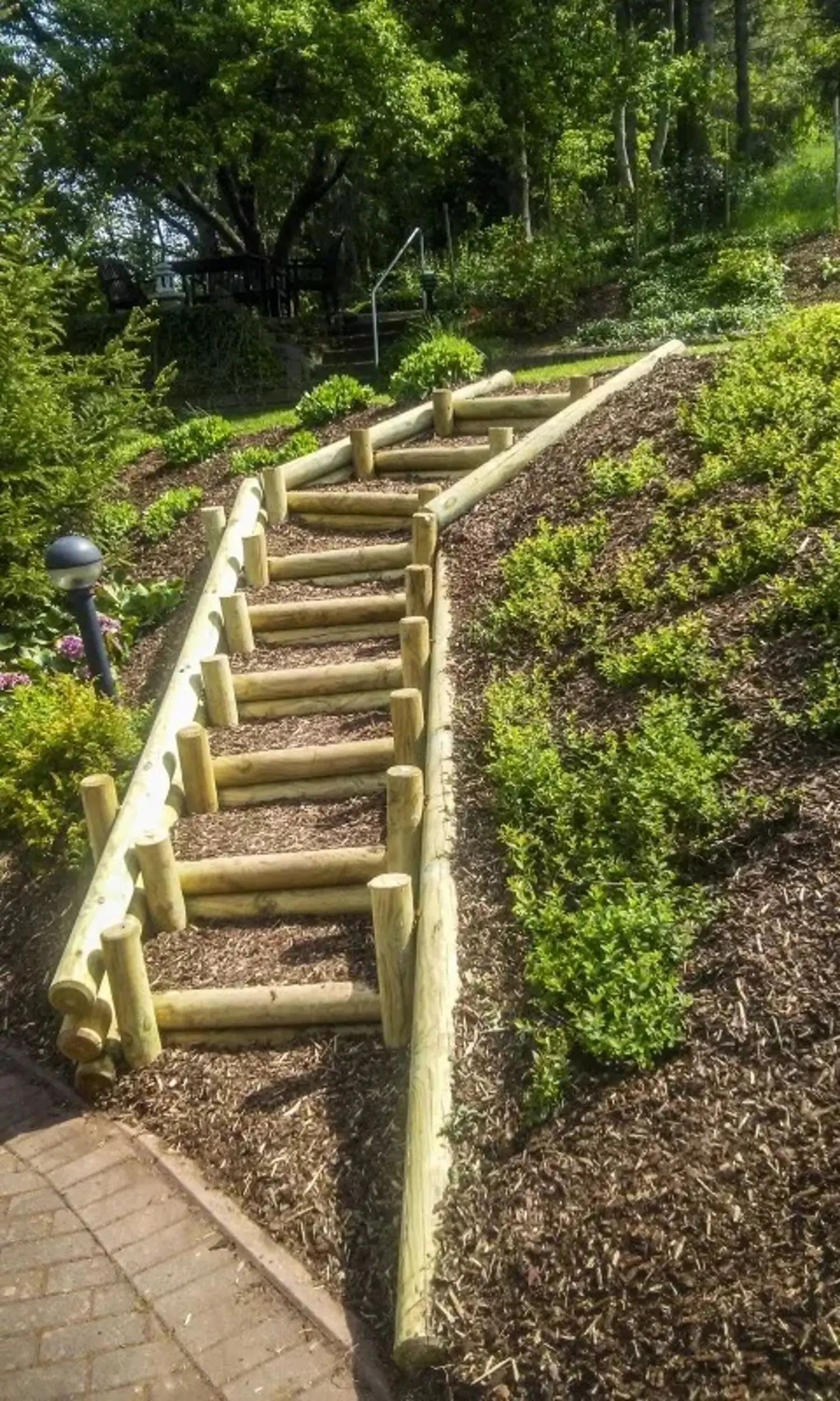 Holztreppe führt einen mit Rindenmulch bedeckten Hang hinauf
