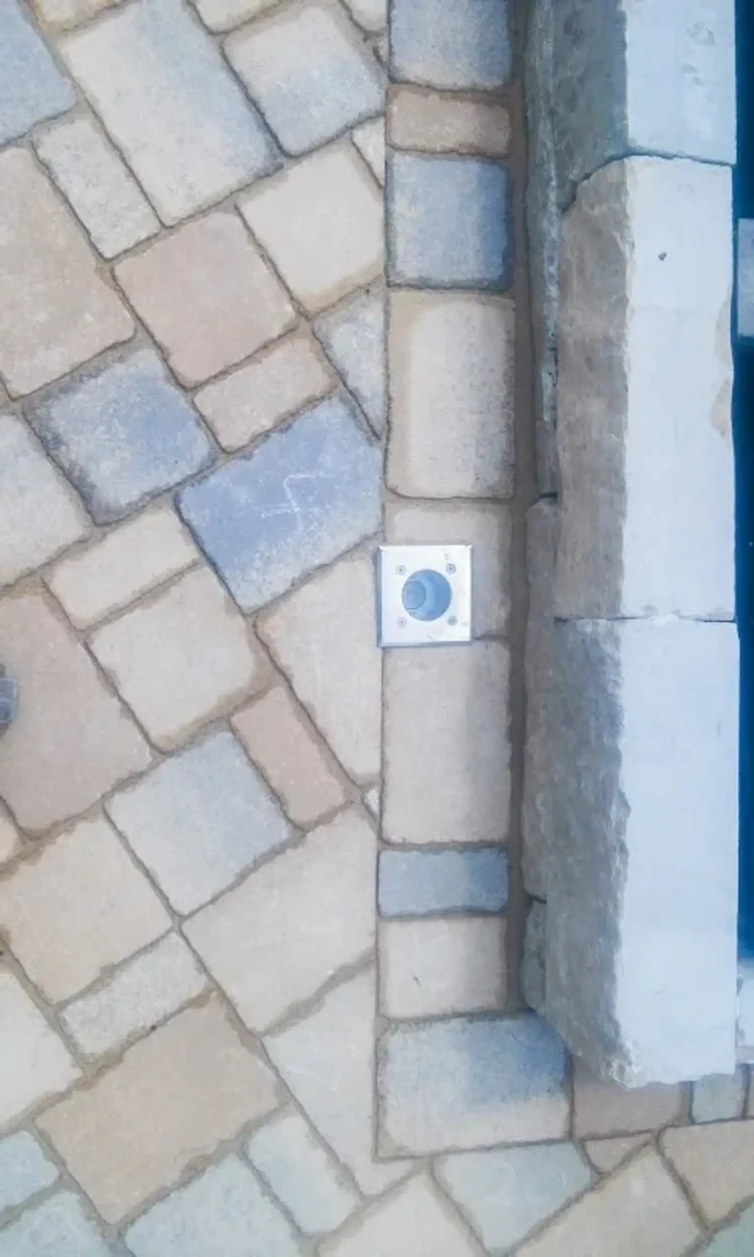 Pflasterweg in Beige und Blau mit quadratischem Bodeneinbaustrahler